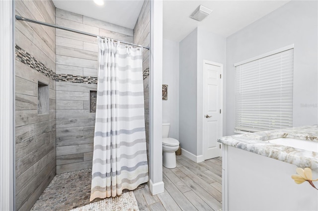 11001 225th Rd, Live Oak, FL 32060 - bathroom featuring toilet, vanity, tiled shower, baseboards, and wood finish floors