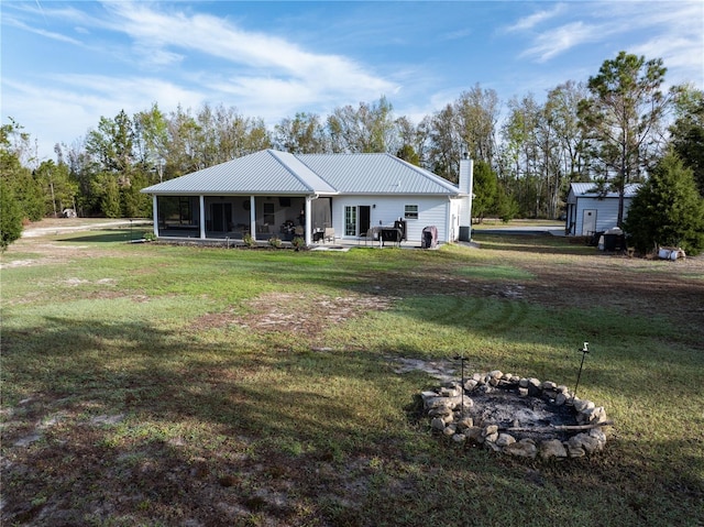 11001 225th Rd, Live Oak, FL 32060 - view of front of home with a chimney, a front yard, metal roof, and a sunroom