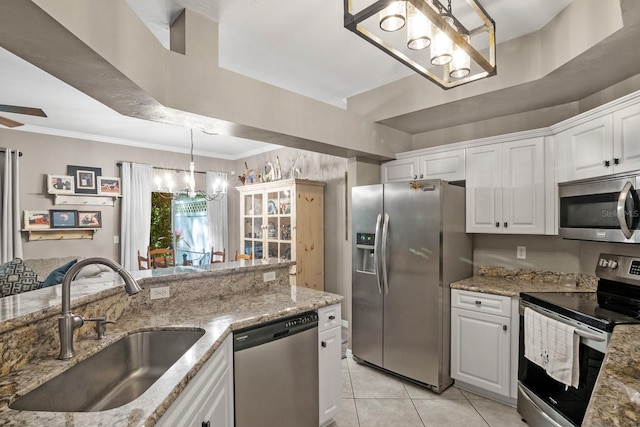 kitchen featuring appliances with stainless steel finishes, a chandelier, a sink, white cabinetry, and crown molding