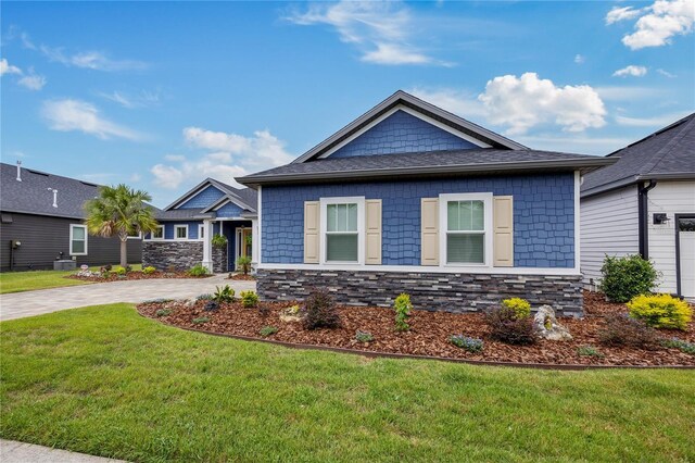 1084 NW 134th Way, Newberry, FL 32669 - craftsman-style house featuring a front yard, stone siding, and driveway