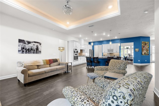 1084 NW 134th Way, Newberry, FL 32669 - living room featuring dark wood-type flooring, a tray ceiling, baseboards, recessed lighting, and crown molding