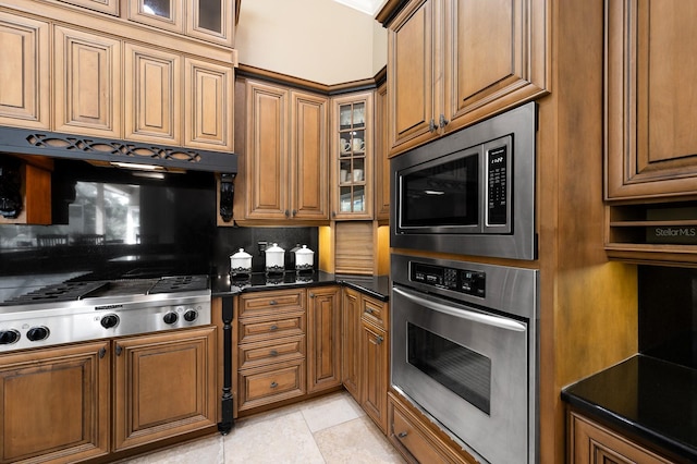3533 SW 87th Dr, Gainesville, FL 32608 - kitchen with stainless steel appliances, brown cabinetry, and decorative backsplash