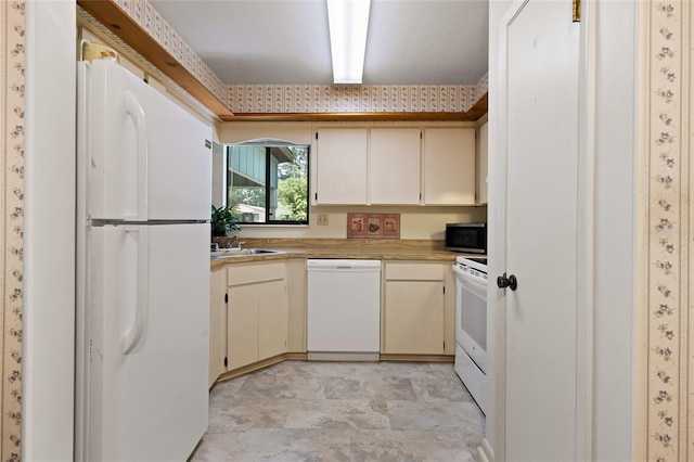 8689 NW 42nd Dr, Gainesville, FL 32653 - kitchen with white appliances, light countertops, stone finish flooring, and cream cabinetry