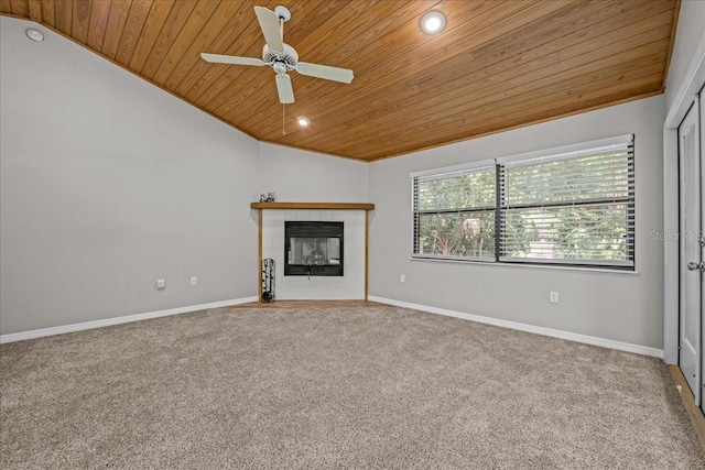 unfurnished living room featuring wood ceiling, lofted ceiling, a fireplace, ceiling fan, and carpet flooring