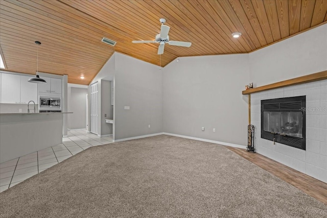 unfurnished living room featuring wooden ceiling, a fireplace, vaulted ceiling, ceiling fan, and a sink