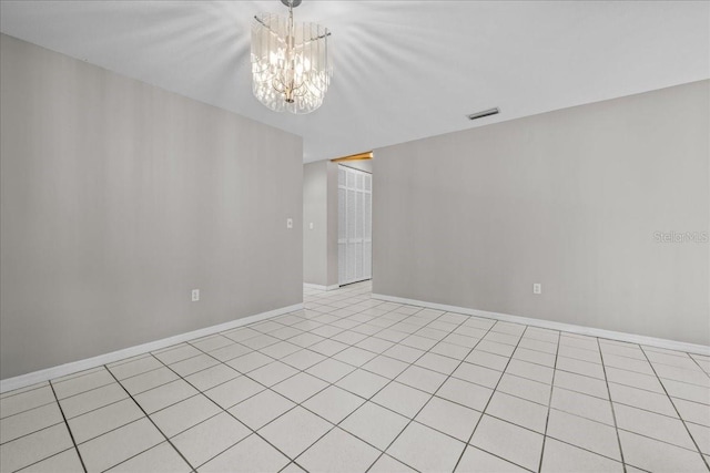 spare room with a chandelier, baseboards, and light tile patterned floors