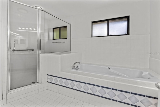 bathroom featuring a stall shower, a bath, and tile patterned floors