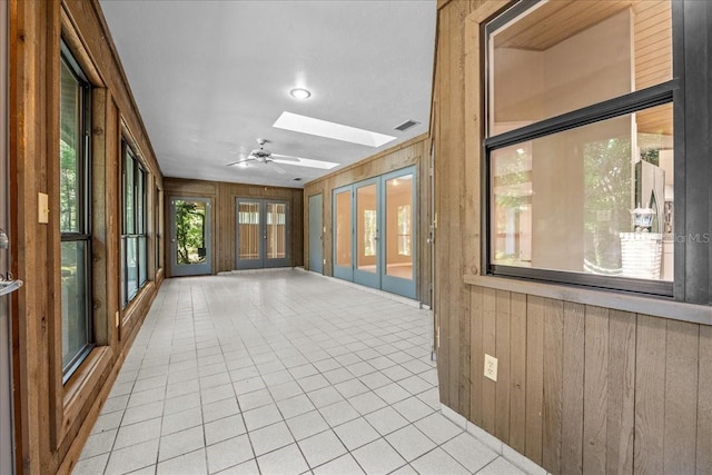 unfurnished sunroom with french doors and a skylight