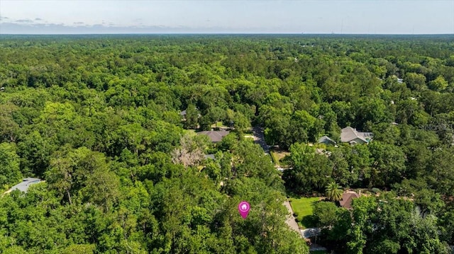 aerial view of property and surrounding area featuring a heavily wooded area