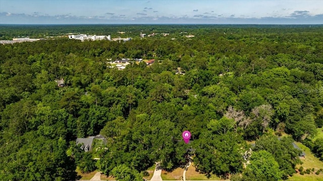 aerial view of property's location featuring a forest