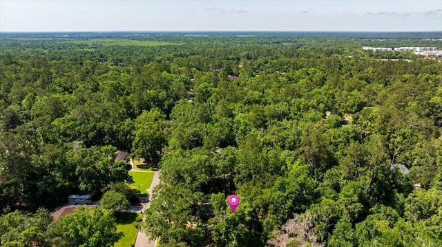 view of property location with a forest