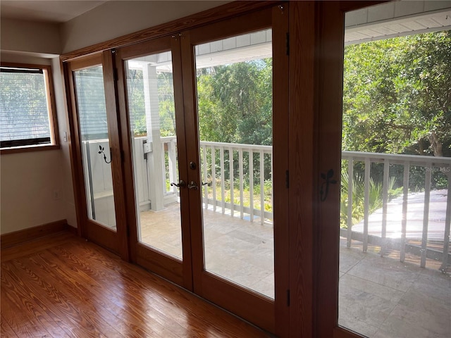 doorway with wood finished floors, french doors, and baseboards