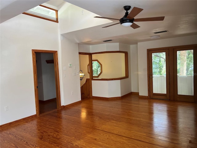 spare room with baseboards, wood finished floors, and a ceiling fan
