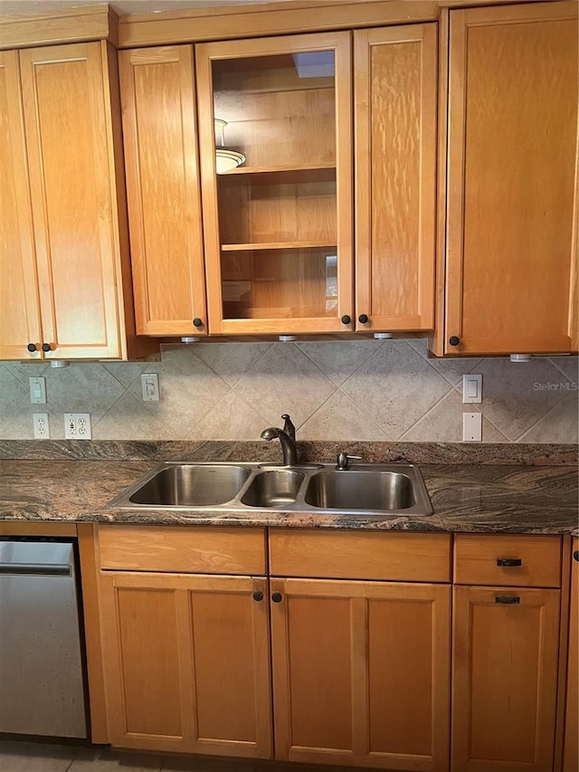 kitchen featuring a sink, backsplash, dishwasher, and dark countertops