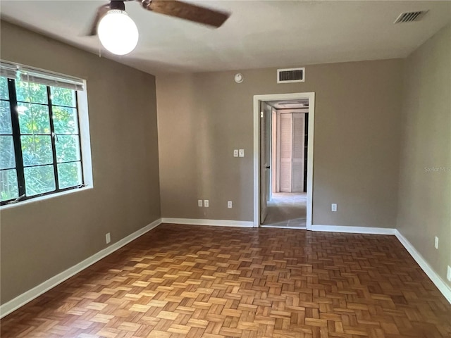 spare room with ceiling fan and baseboards