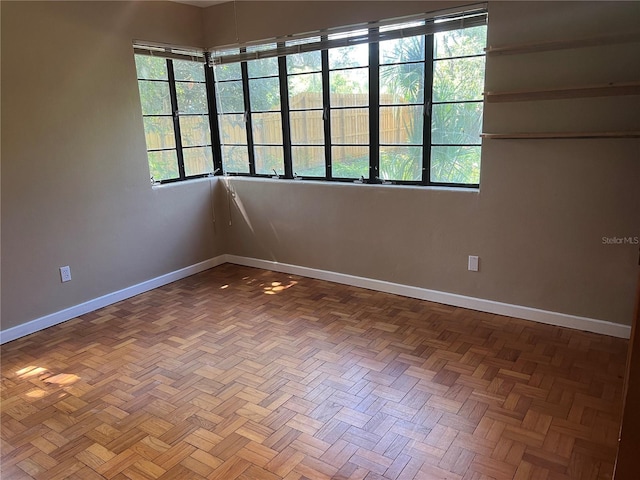 unfurnished room with healthy amount of natural light and baseboards