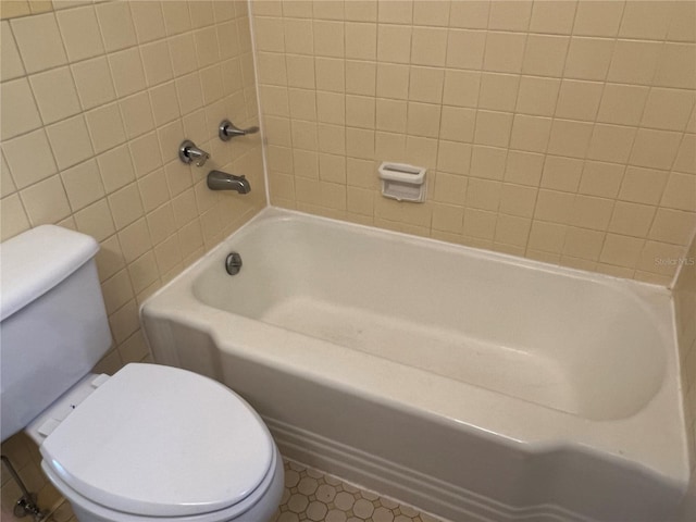 bathroom with toilet, a bath, and a shower