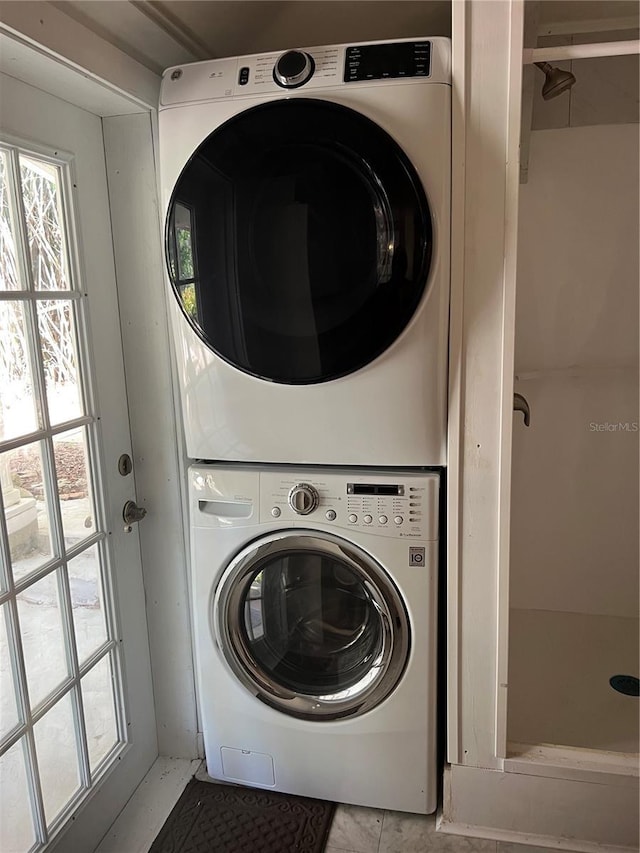 washroom featuring stacked washer / dryer and tile patterned floors