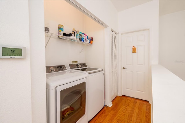 laundry area with washer and dryer and light wood finished floors