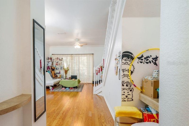 hall featuring wood finished floors and crown molding