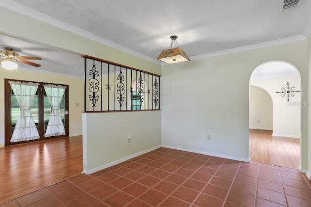 8804 NW 176th Ter, Alachua, FL 32615 - empty room featuring ceiling fan, crown molding, dark wood-style flooring, arched walkways, and baseboards