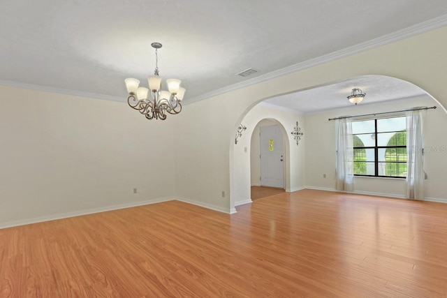 8804 NW 176th Ter, Alachua, FL 32615 - empty room featuring arched walkways, light wood-style floors, a chandelier, crown molding, and baseboards