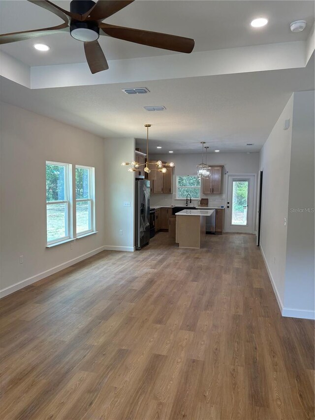 2522 SE 11th Ave, Gainesville, FL 32641 - unfurnished living room featuring a chandelier, a ceiling fan, recessed lighting, and wood finished floors