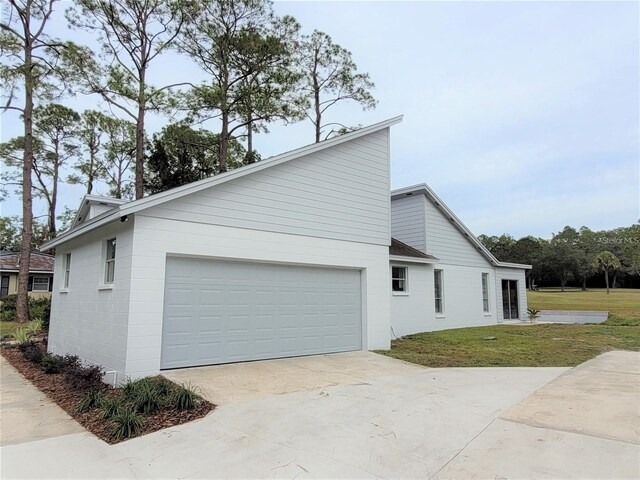 6015 SW 35th Way, Gainesville, FL 32608 - view of side of home featuring concrete driveway, a yard, and a garage