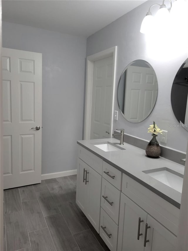 6015 SW 35th Way, Gainesville, FL 32608 - bathroom featuring double vanity, wood finish floors, and baseboards