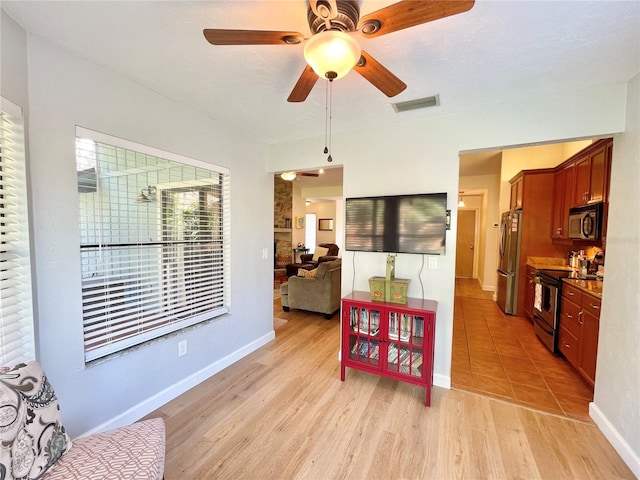 4370 NW 60th Ter, Gainesville, FL 32606 - kitchen featuring stainless steel appliances, a ceiling fan, light wood-style flooring, baseboards, and dark countertops