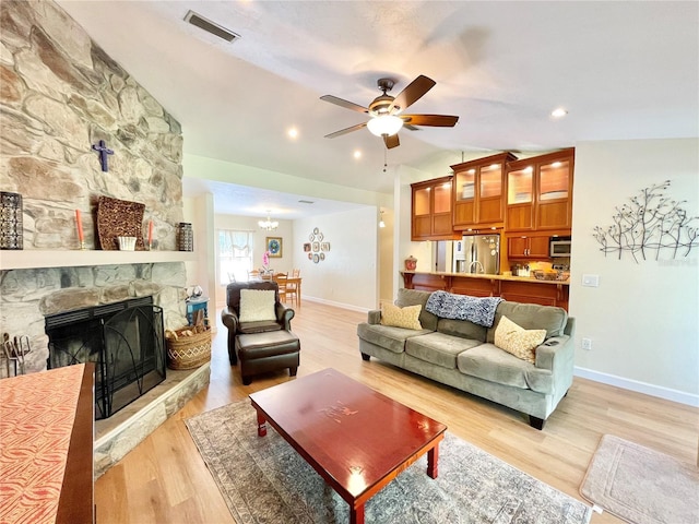 4370 NW 60th Ter, Gainesville, FL 32606 - living area featuring vaulted ceiling, a ceiling fan, baseboards, light wood finished floors, and a fireplace