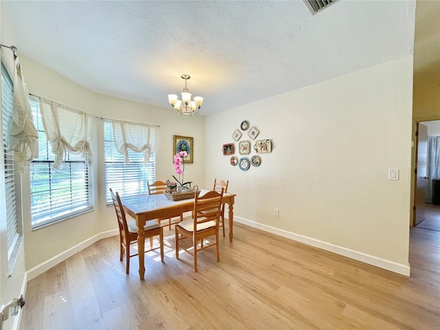4370 NW 60th Ter, Gainesville, FL 32606 - dining room with light wood finished floors, a chandelier, and baseboards