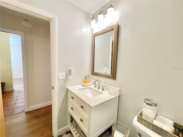 4370 NW 60th Ter, Gainesville, FL 32606 - bathroom with vanity, toilet, wood finished floors, and baseboards