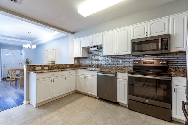 528 NW 39th Rd Unit 101, Gainesville, FL 32607 - kitchen with appliances with stainless steel finishes, a sink, a chandelier, tasteful backsplash, and white cabinetry