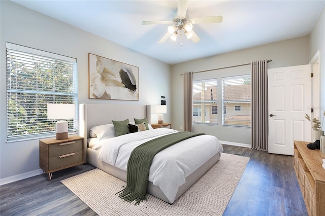 528 NW 39th Rd Unit 101, Gainesville, FL 32607 - bedroom featuring baseboards, dark wood finished floors, and ceiling fan