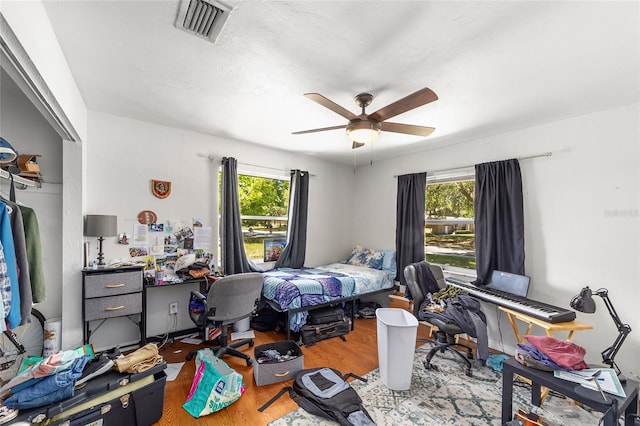 6117 NW 23rd Ter, Gainesville, FL 32653 - bedroom with wood finished floors, multiple windows, a closet, and a ceiling fan