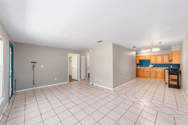 6117 NW 23rd Ter, Gainesville, FL 32653 - kitchen with baseboards, light tile patterned floors, a chandelier, and light countertops