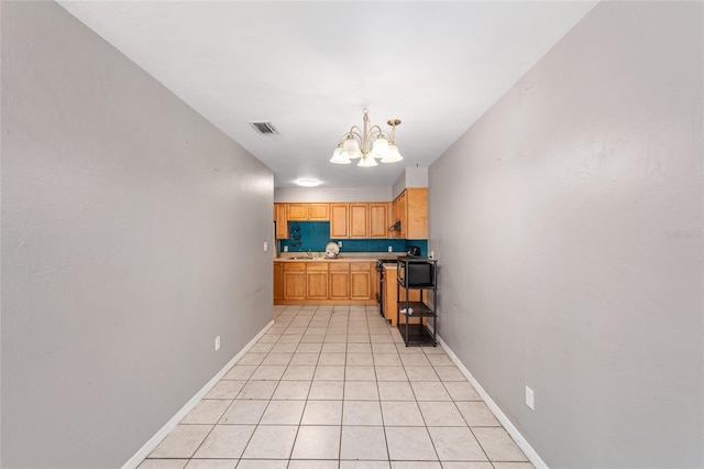 6117 NW 23rd Ter, Gainesville, FL 32653 - kitchen featuring a chandelier, light countertops, baseboards, and black microwave