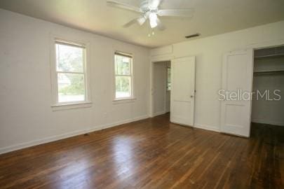 1627 NW 8th Ave, Gainesville, FL 32603 - unfurnished bedroom with multiple windows, dark wood-style floors, and baseboards