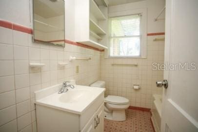 1627 NW 8th Ave, Gainesville, FL 32603 - full bath featuring tile walls, toilet, vanity, and tile patterned floors
