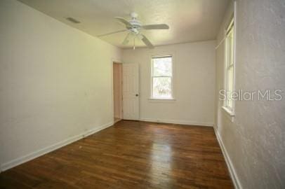 1627 NW 8th Ave, Gainesville, FL 32603 - spare room with wood finished floors, ceiling fan, and baseboards