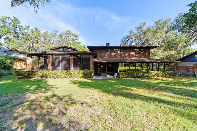 6015 SW 36th Way, Gainesville, FL 32608 - rear view of property featuring a sunroom, a chimney, and a yard