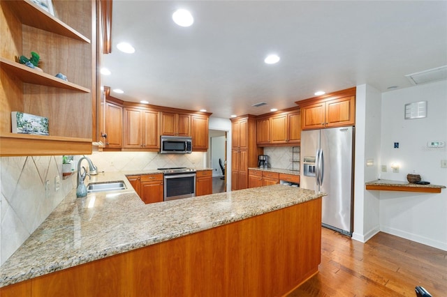 6015 SW 36th Way, Gainesville, FL 32608 - kitchen with stainless steel appliances, a sink, open shelves, light wood-style floors, and brown cabinets
