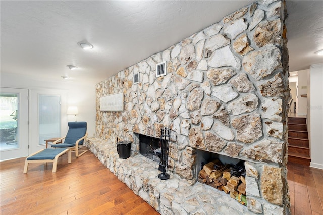 6015 SW 36th Way, Gainesville, FL 32608 - living area featuring a stone fireplace, wood-type flooring, and baseboards