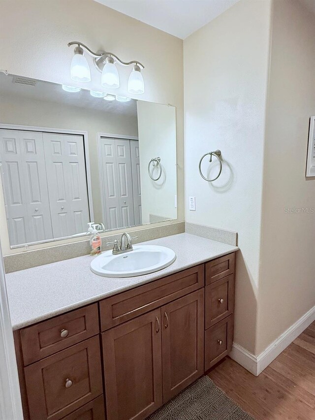 1425 S Central Ave, Flagler Beach, FL 32136 - bathroom featuring wood finished floors, vanity, and baseboards
