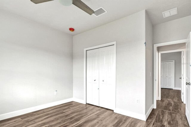 6669 SW 10th Ln, Gainesville, FL 32607 - unfurnished bedroom with baseboards, dark wood-style flooring, a closet, and a ceiling fan