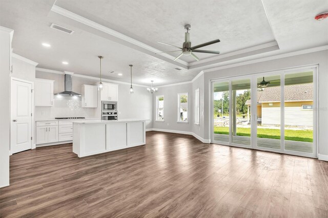6669 SW 10th Ln, Gainesville, FL 32607 - kitchen featuring a ceiling fan, appliances with stainless steel finishes, wall chimney range hood, open floor plan, and dark wood-style flooring