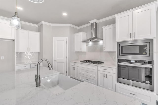 6669 SW 10th Ln, Gainesville, FL 32607 - kitchen featuring appliances with stainless steel finishes, wall chimney range hood, a sink, tasteful backsplash, and white cabinets