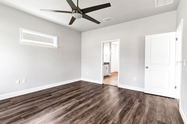 6669 SW 10th Ln, Gainesville, FL 32607 - unfurnished bedroom featuring dark wood-style flooring, baseboards, a ceiling fan, and ensuite bathroom