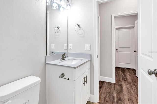 6669 SW 10th Ln, Gainesville, FL 32607 - half bath with wood finished floors, toilet, vanity, and baseboards